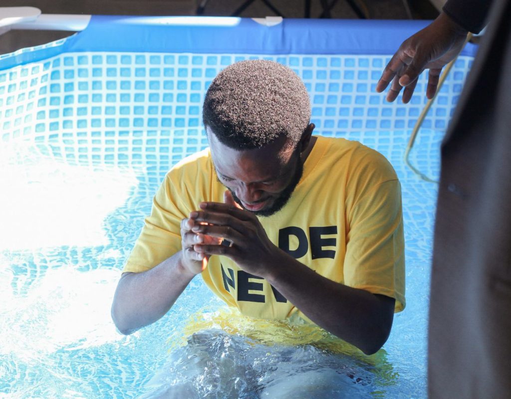 Young man getting baptised in water